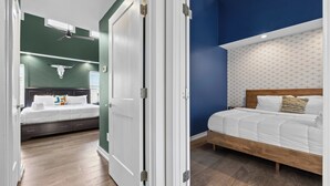 A hotel room with two beds, a ceiling fan, a skull decoration, and patterned wallpaper. - The Tiger Den - Hottub -Rooftop- Gameroom (Nashville)