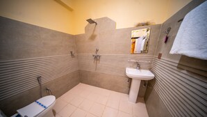 Un baño con inodoro, bidé, lavabo y ducha.