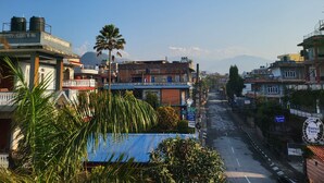 Un hotel con un cartel que indica su nombre y vistas a las montañas al fondo.