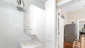 A laundry room with a washing machine, dryer, and a utility cabinet.