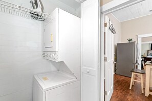 Een wasserette met een wasmachine, droger en een opslagkast.