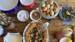 A table with various food items, including a dish with green beans, eggs, and a bowl of sauce. - Saturn's Return (Friday Harbor)