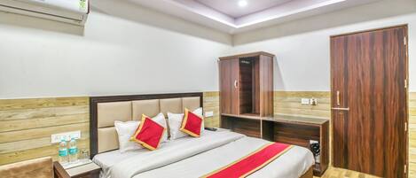 A hotel room with a bed, nightstand, wardrobe, and ceiling fan.