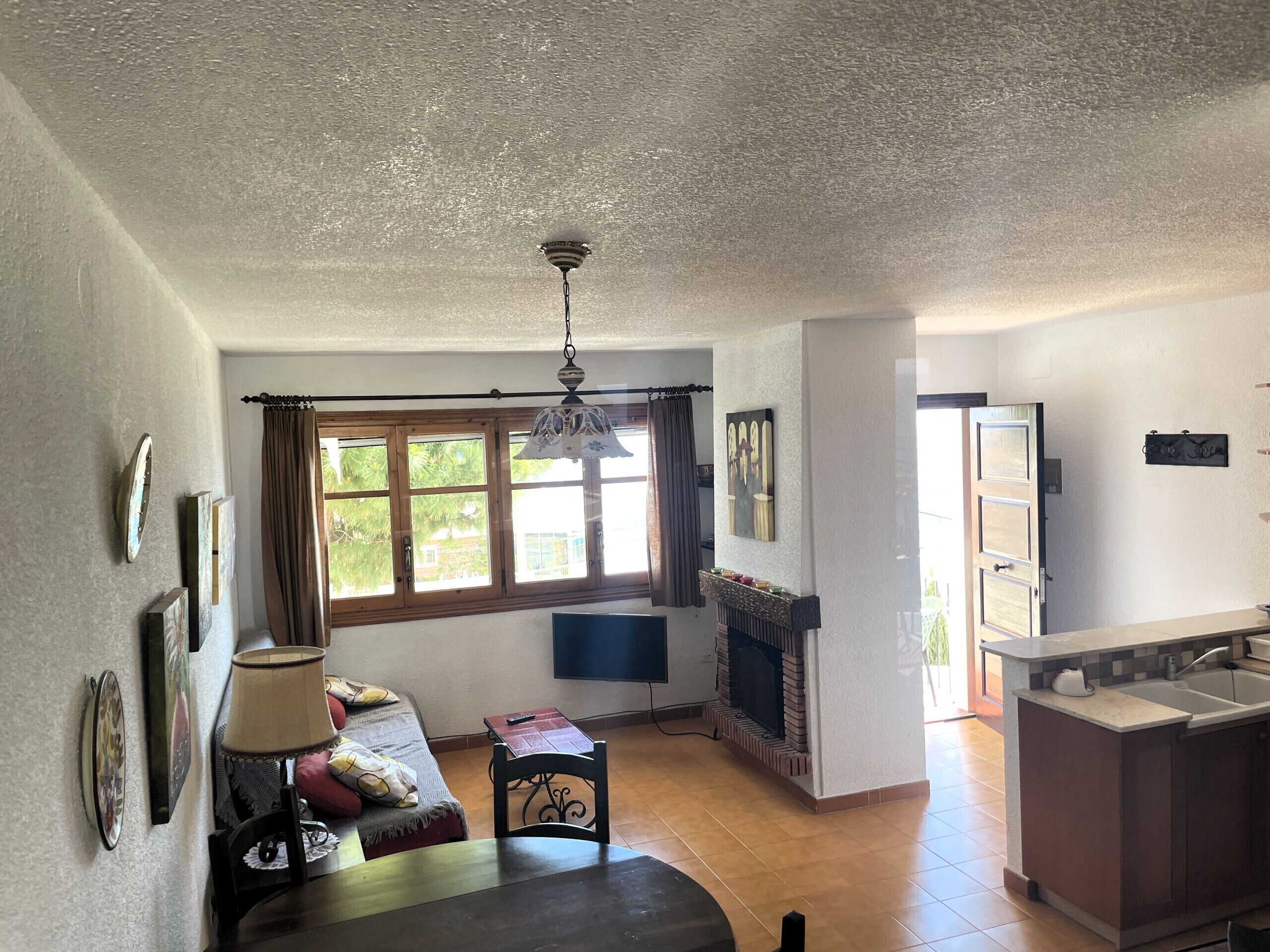 Una sala de estar amplia con chimenea, comedor y cocina.