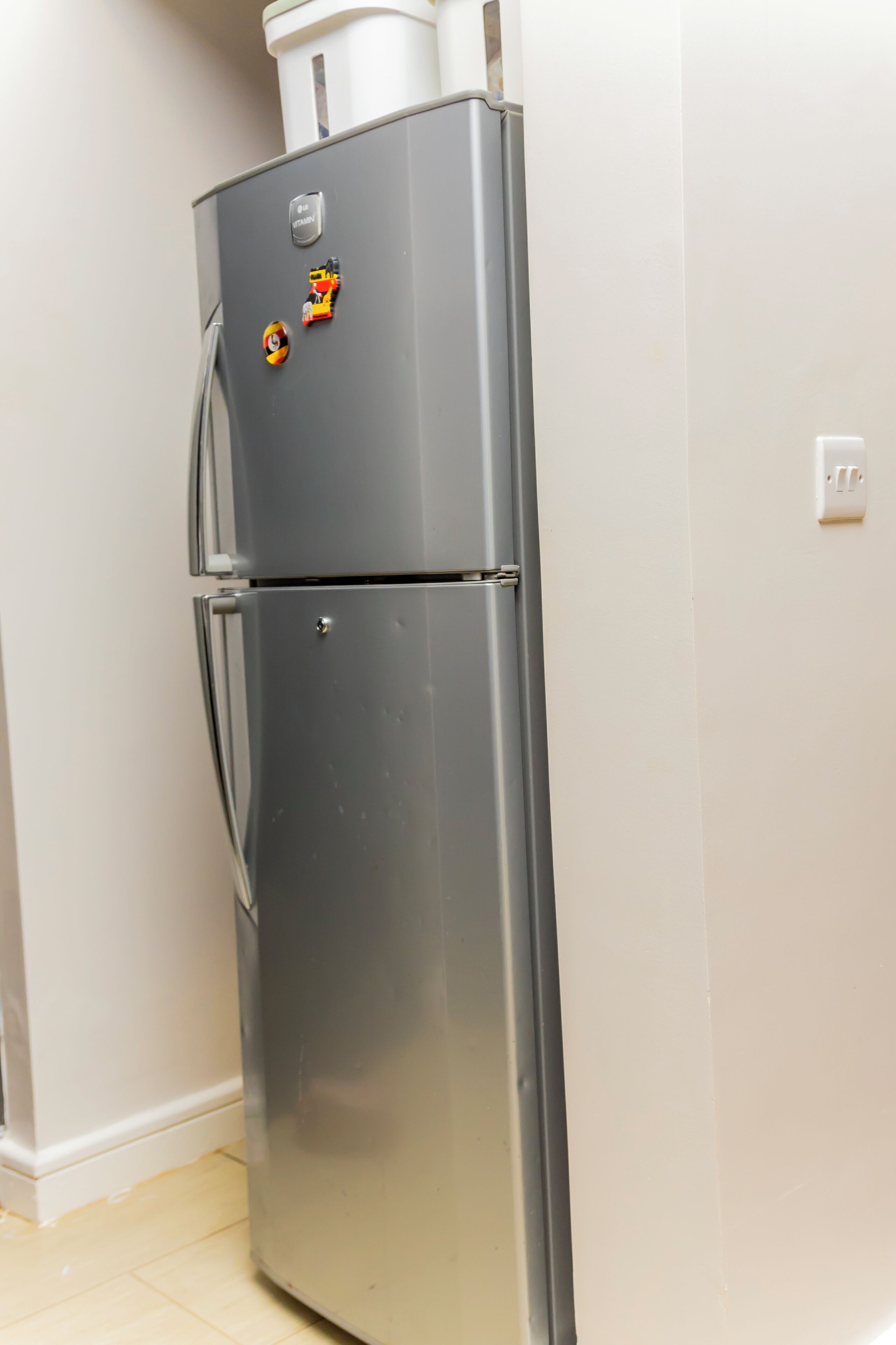 A stainless steel refrigerator with a freezer compartment on top, a handle on the door, and a small logo on the top.