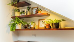 Une cuisine avec des étagères en bois où sont disposées des plantes en pot et des ustensiles de cuisine.