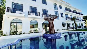 Outdoor pool, open 6:00 AM to 10:00 PM, pool loungers