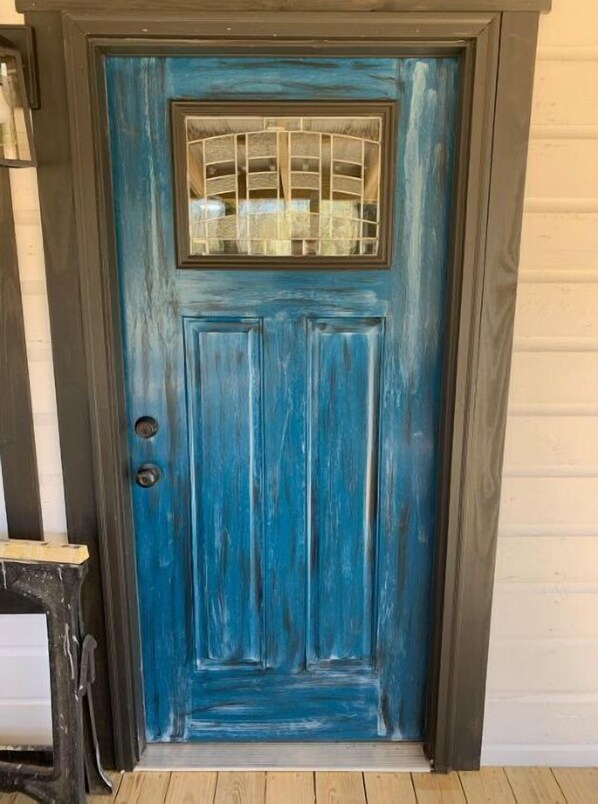 A blue door with a glass panel and a small window above it.