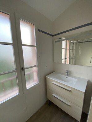 Regadera, secadora de cabello, toallas, papel de baño 