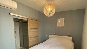 A bedroom with a bed, a wardrobe, and a ceiling light fixture. - Renovated town house in the heart of Arcachon (Arcachon)