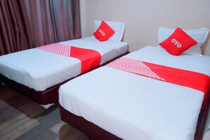 Two single beds with white bedding and red accents, including pillows and bedspreads. - OYO 91876 Hotel Putri Gading 2 (Bengkulu)