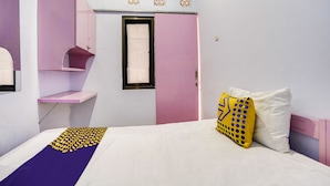 A bedroom with a bed, a pink wardrobe, a window, and a mirror. - OYO Life 91626 Rr Kost Putri Syariah (Lumajang)