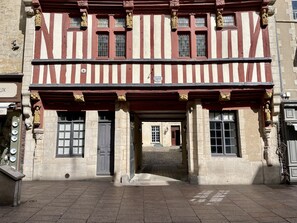 A historic building with a timber-framed facade, stone walls, and a ground-level entrance.