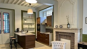 Eine moderne Küche mit einer zentralen Kochinsel, Barhocker und einem Kamin.