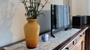 A wooden cabinet with a vase of flowers on a lace doily.