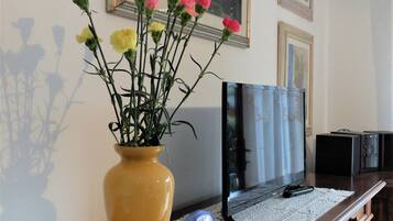 A wooden cabinet with a vase of flowers on a lace doily.