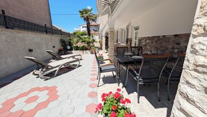 A patio area with a table and chairs, a sun lounger, and potted plants. - Easy City Access: 3BR w/ Terrace & Private Carport (Zadar)