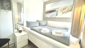 Une chambre à coucher avec un lit, une table de chevet, une lampe et une grande fen être.