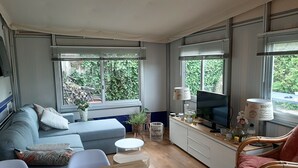 Ein kompakter Wohnbereich mit Sofa, Fernseher und Essecke.