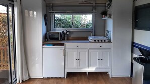 Eine kompakte Küche mit Mikrowelle, Toaster und kleinem Kühlschrank.