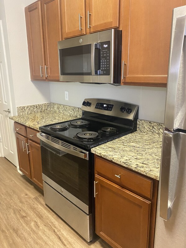 Enjoy cooking in this well-equipped kitchen with a range, microwave, and refrigerator.
