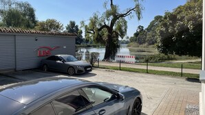 Um carro estacionado em frente a um edifício com uma placa indicando 