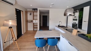 Et moderne køkken med spiseplads, integreret hårde hvidevarer og en kompakt indretning.