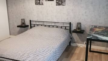 Una camera da letto con un letto, comodini, una lampada e decorazioni a parete.