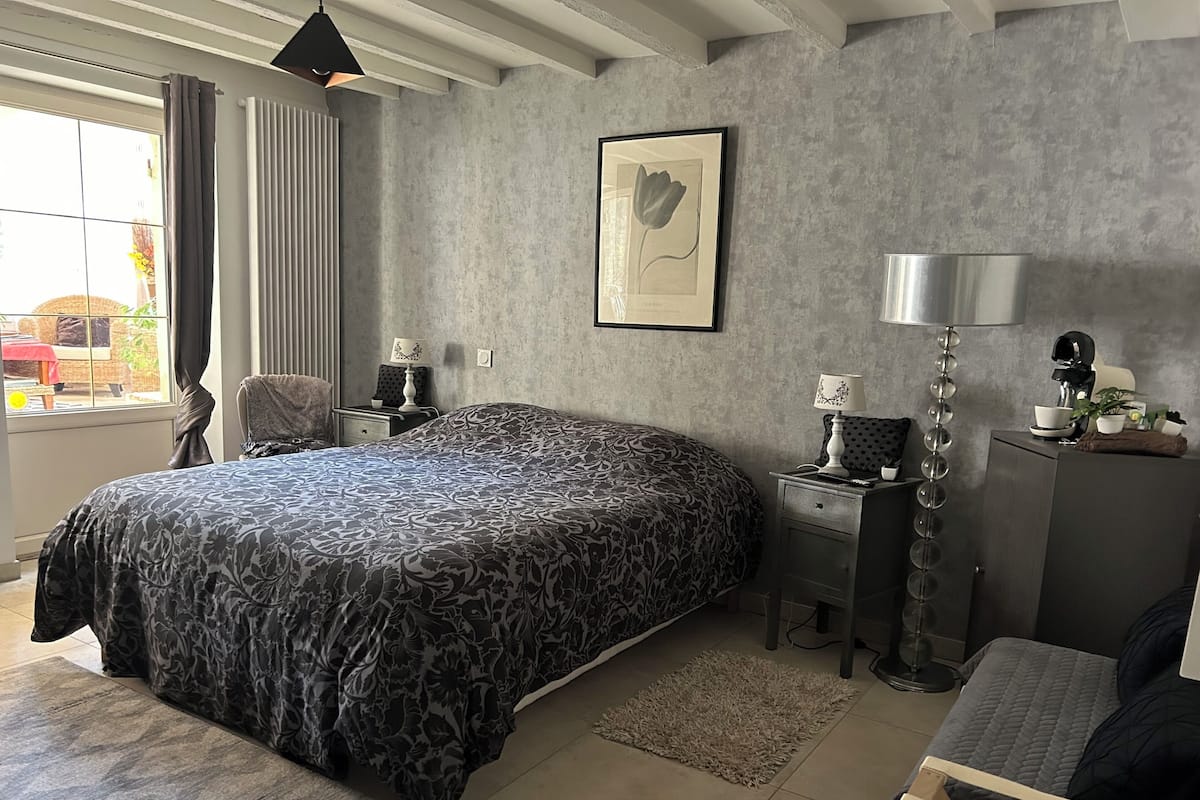 Une chambre moderne avec un grand lit, des tables de chevet, un bureau et une chaise.