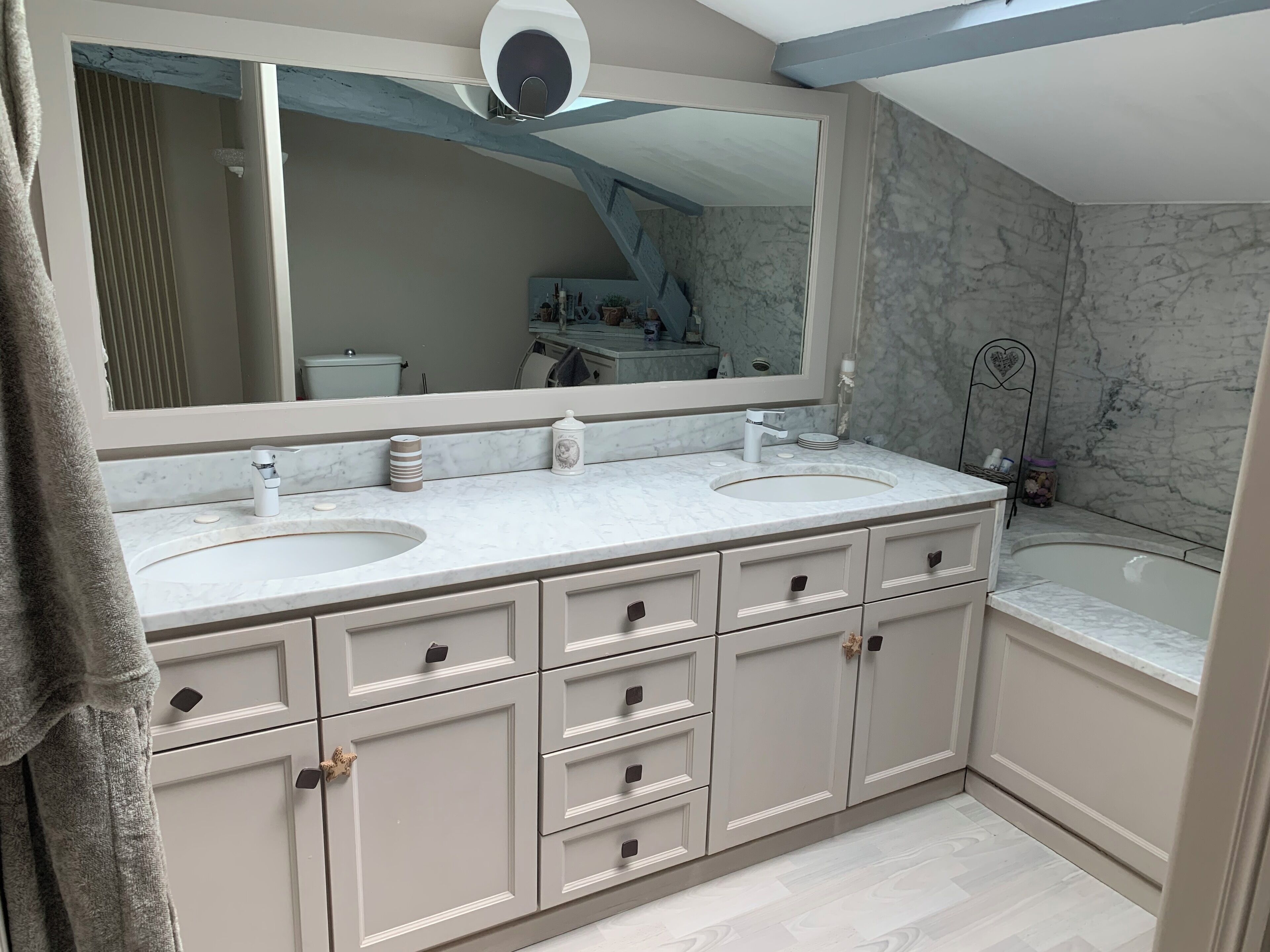 A bathroom with two sinks, a large mirror, and a bathtub.