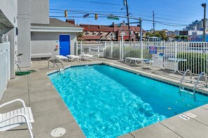 A rectangular swimming pool with clear blue water, surrounded by a white fence and lounge chairs. - Luxury 3 Bedroom Bayview Condo with Pool - 22nd St! Overlooking Bahia Marina and Fish Tales! Mariner's Watch #304 (Ocean City)