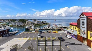 Een jachthaven met aangemeerde boten, een parkeerplaats en gebouwen met uitzicht op het water.