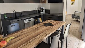 Una cucina moderna con un tavolo da pranzo in legno, sedie nere e forno integrato.