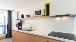 A modern kitchen with a built-in microwave, a coffee maker, and a sink. - Home Club (Lavachet) by Interhome (Tignes)