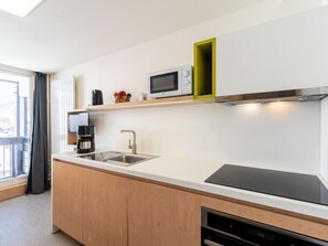 A modern kitchen with a built-in microwave, a coffee maker, and a sink. - Home Club (Lavachet) by Interhome (Tignes)