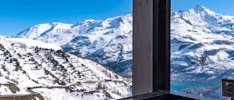 Een berglandschap met besneeuwde toppen en een helderblauwe lucht.