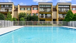 Una piscina rodeada de edificios de apartamentos con balcones.