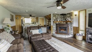 A spacious living room with a fireplace, leather sofas, and a dining area visible in the background. - Your ultimate Sugar Mountain getaway - just steps from the slopes. (Sugar Mountain)