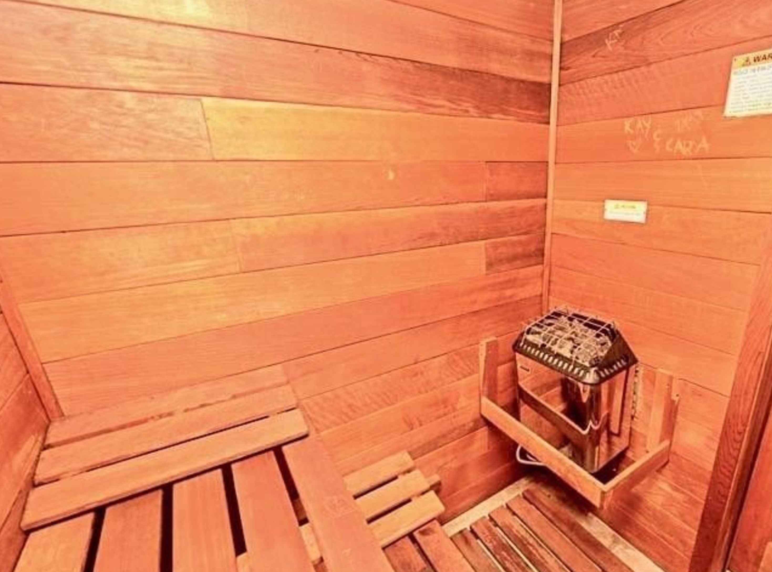 Une cabane en bois avec un petit banc en bois et un panier tressé.