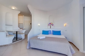 Une chambre d’hôtel moderne équipée d’un lit, d’un coin salon et d’une petite table.