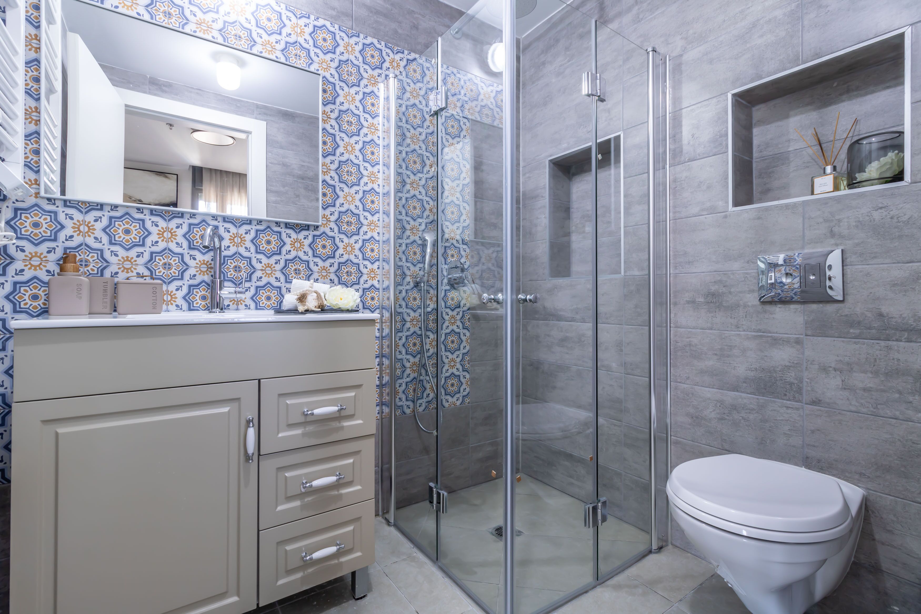 A bathroom with a shower, toilet, and vanity with drawers.