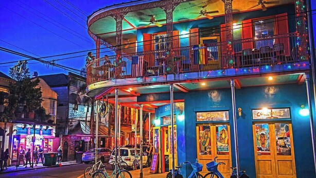 A multi-story building with balconies, a ground-level entrance, and a sign reading "601". - Fab Marigny | 2BD Flat | Close to French Quarter (New Orleans)