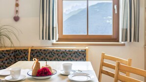 Une table à manger avec des assiettes, des tasses et un objet décoratif. Une chaise en bois est placée près de la table.