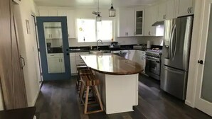 Una cocina moderna con una isla central, electrodomésticos de acero inoxidable y una pared de acento azul.