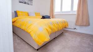 Un dormitorio con cama, ventana y radiador.