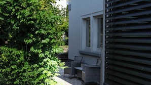 A residential building with a paved patio, a small garden, and a window with blinds. - Friendly, wheelchair-accessible vacation rental in Lengfurt: The Berger Family (Triefenstein)