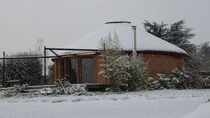 Een huis bedekt met sneeuw, met een zichtbare schoorsteen, een raam en een deur.
