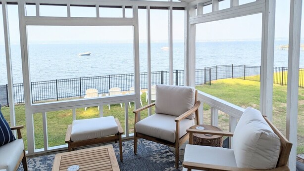 A covered outdoor seating area with a view of the sea. - Cozy Waterfront Home In Portsmouth (Portsmouth)