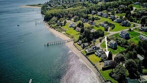 An aerial view of a coastal residential area with houses, a pier, and a beach. - Cozy Waterfront Home In Portsmouth (Portsmouth)