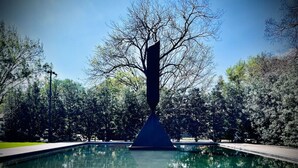 A tranquil park with a reflective pool, a central sculpture, and surrounding trees. - Art and Foodie Lover`s Dream -Live Like a Local in Montrose (Houston)